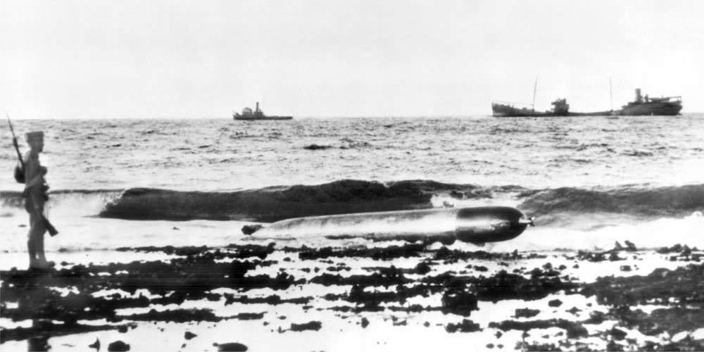 Морпех охраняет выброшенную на берег немецкую торпеду G7e. Карибское море, остров Аруба, 16 февраля 1942 года