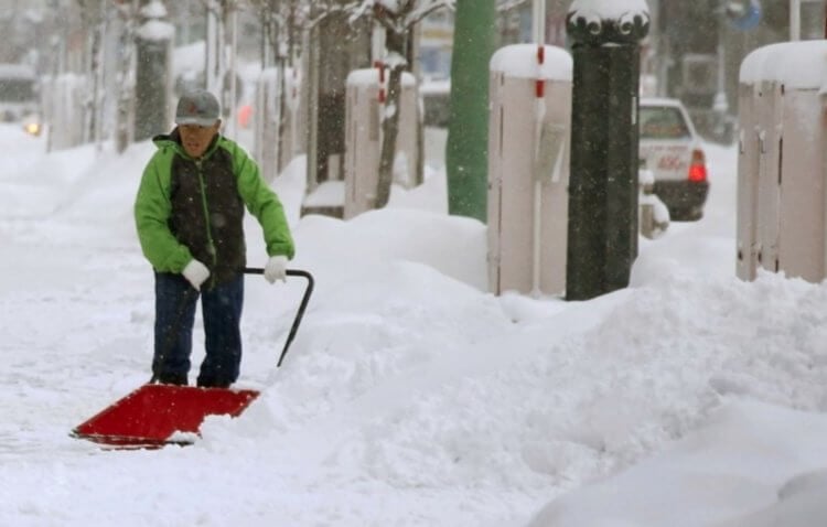 Жизнь в самом снежном городе. Многим людям приходится чистить снег вручную. Источник изображения: travelask.ru. Фото.